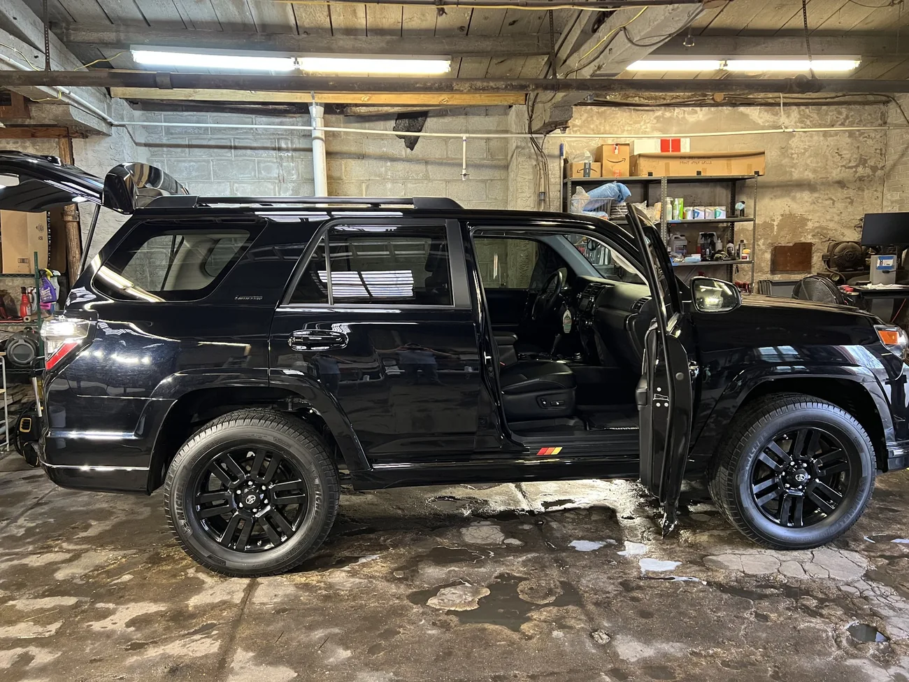 Black Toyota 4Runner being carefully washed in a working garage