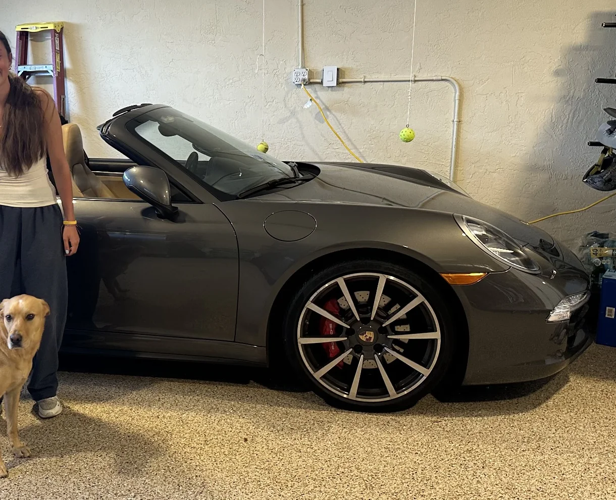 Close-up view of the front side and wheel of a gray Porsche sports car